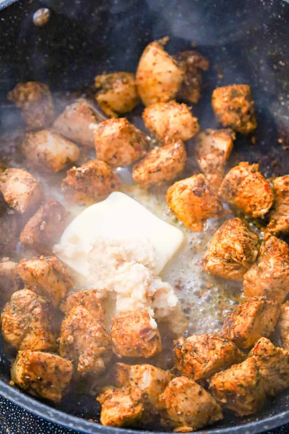 butter and garlic puree added to saute pan with cajun chicken chunks
