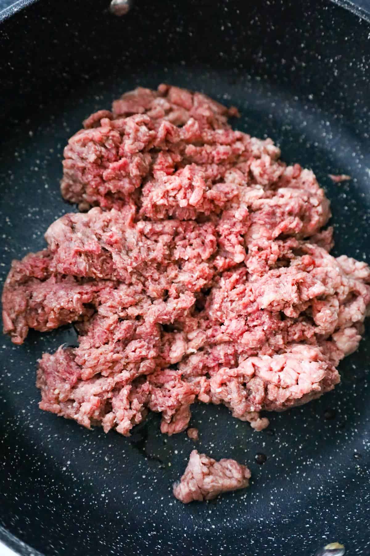 raw ground beef in a saute pan