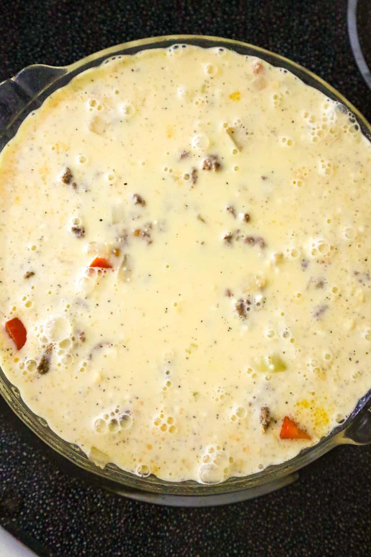 Bisquick mix poured over ground beef in a pie plate