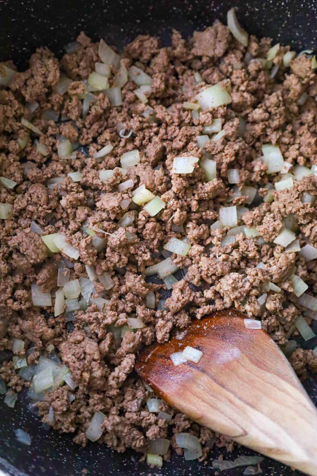 cooked ground beef and diced onions in a saute pan