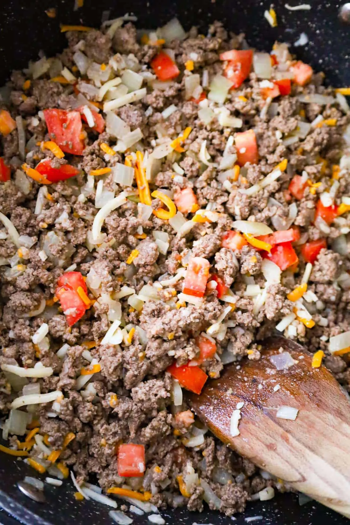diced tomatoes, shredded cheese and cooked ground beef in a saute pan