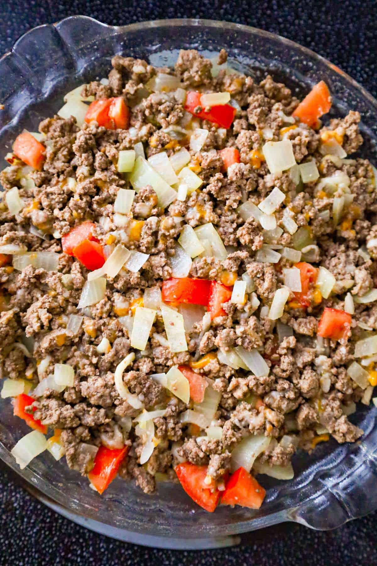 diced tomatoes, diced onions and ground beef in pie plate