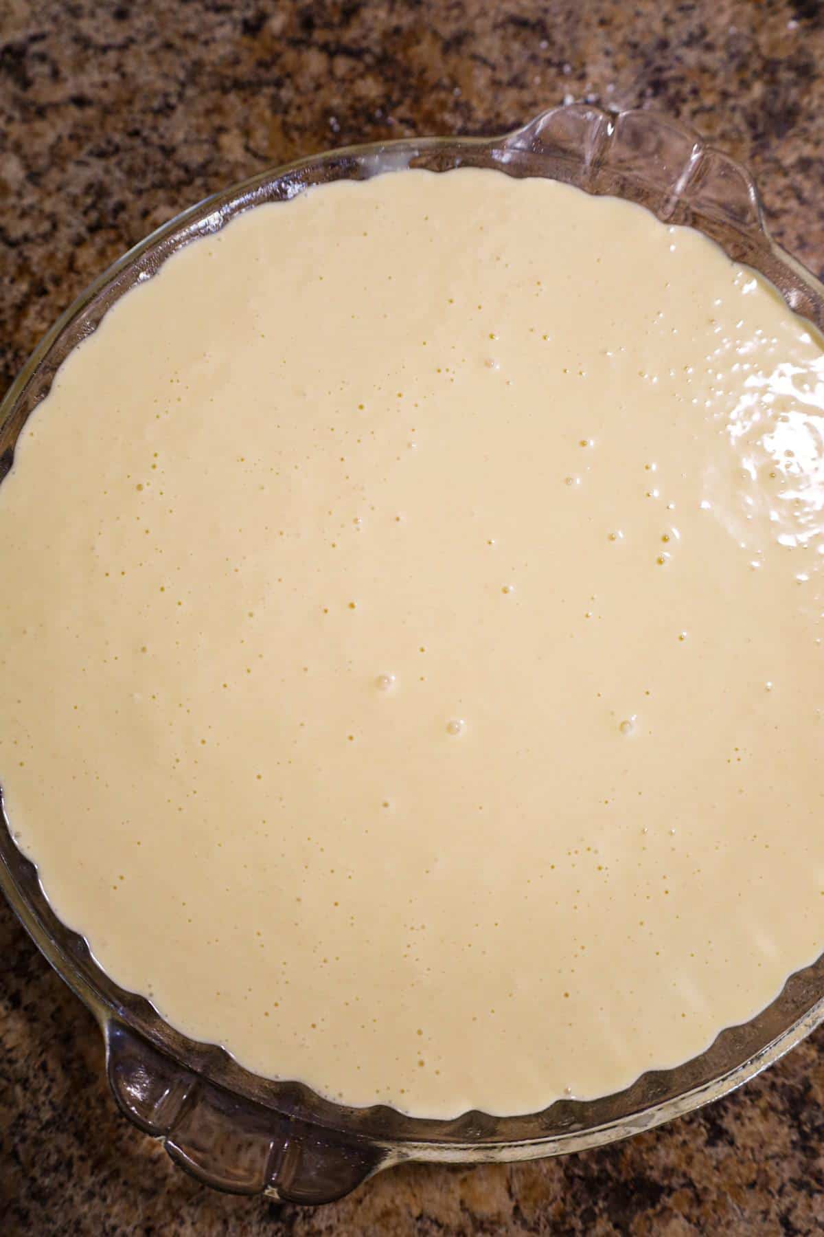 Bisquick batter on top of chicken mixture in a pie plate