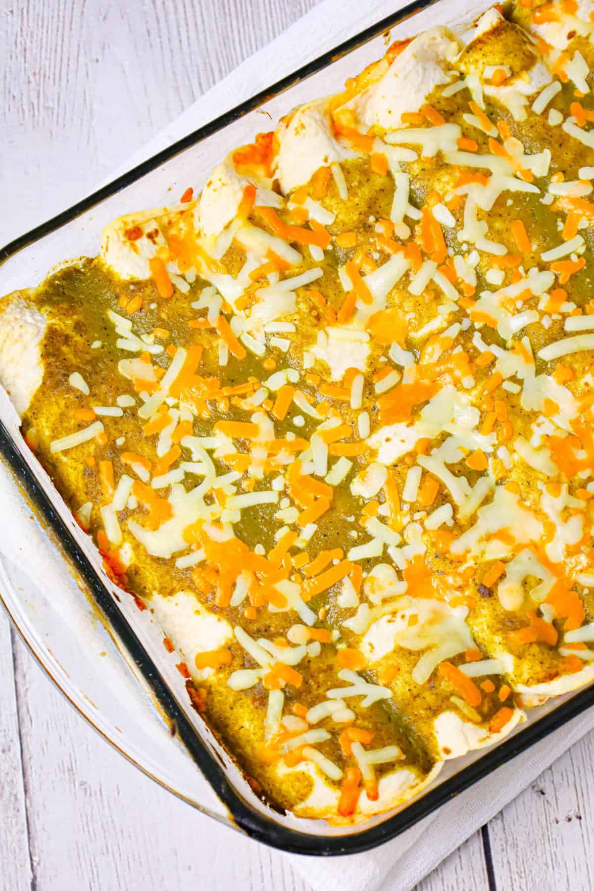 Cream Cheese Chicken Enchiladas are a delicious dinner recipe using shredded rotisserie chicken, sour cream, cream cheese, Rotel and shredded cheese all rolled inside flour tortillas and baked with green enchilada sauce.