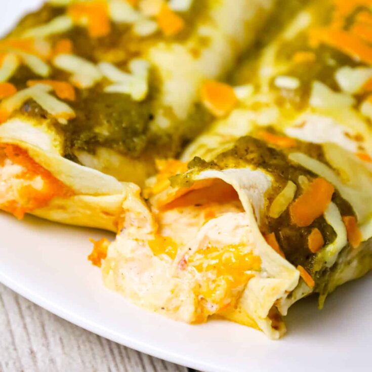 Cream Cheese Chicken Enchiladas are a delicious dinner recipe using shredded rotisserie chicken, sour cream, cream cheese, Rotel and shredded cheese all rolled inside flour tortillas and baked with green enchilada sauce.