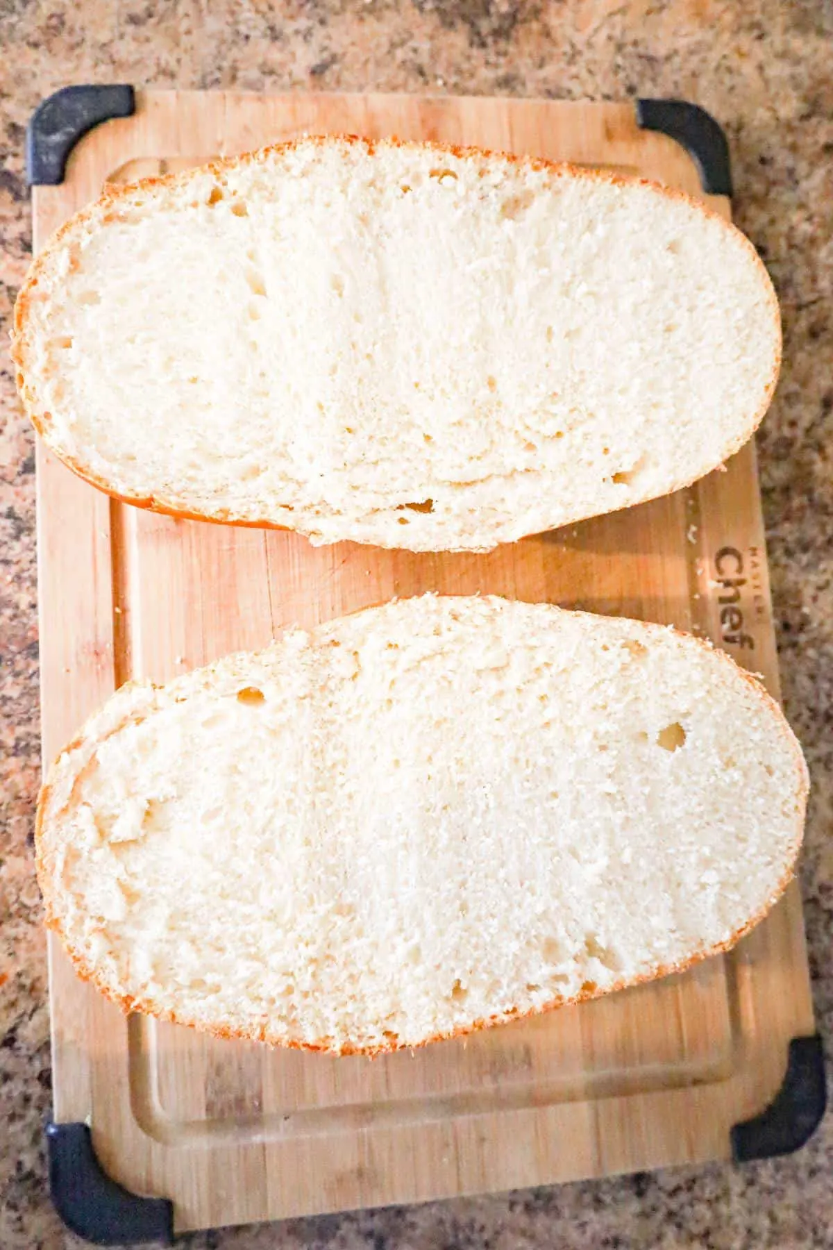 French bread loaf cut in half on cutting board