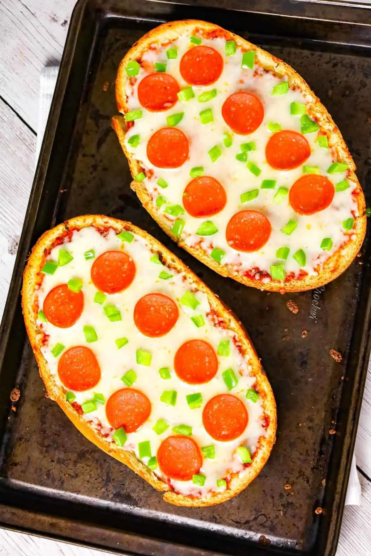 French Bread Pizza is an easy dinner or party snack recipe made with a large loaf of French or Italian bread toasted with garlic butter and topped with pizza sauce, cheese, pepperoni and green peppers.