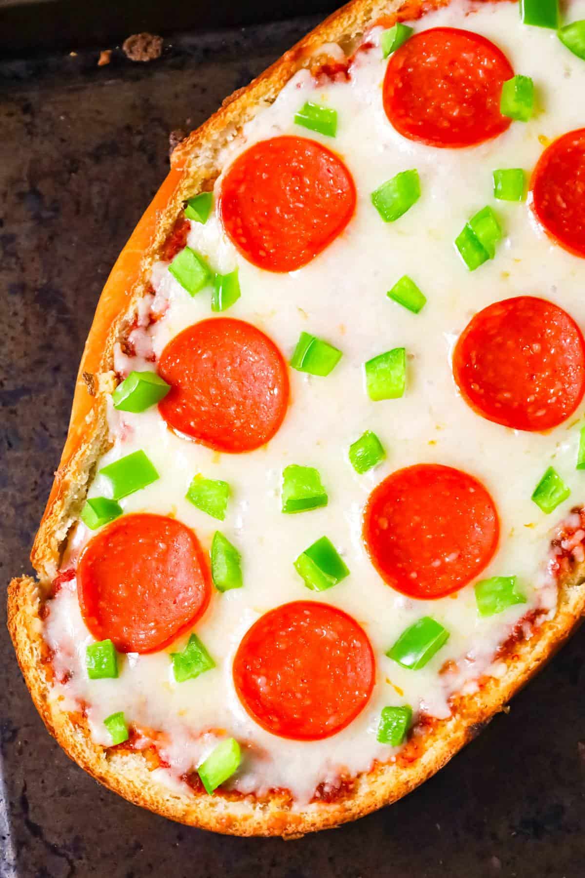 French Bread Pizza is an easy dinner or party snack recipe made with a large loaf of French or Italian bread toasted with garlic butter and topped with pizza sauce, cheese, pepperoni and green peppers.