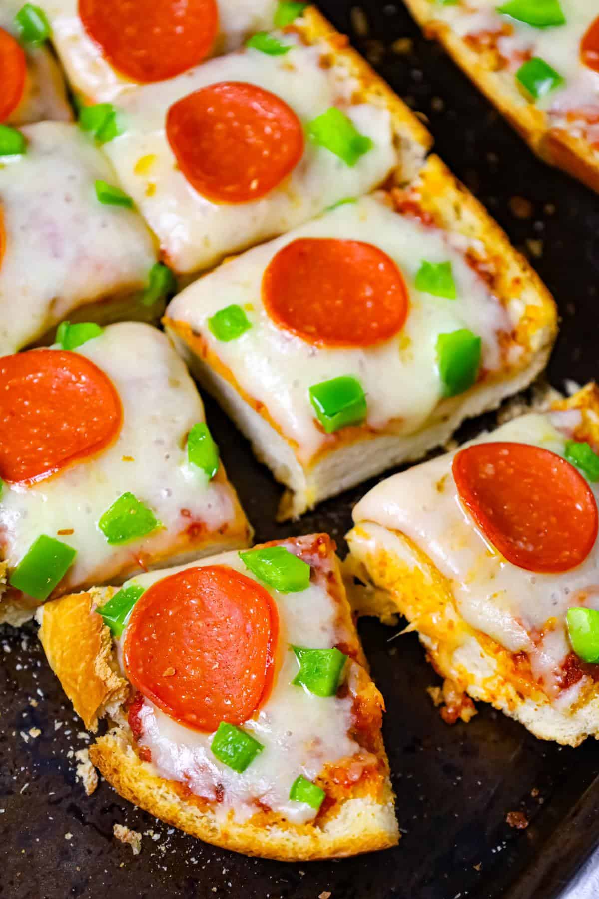 French Bread Pizza is an easy dinner or party snack recipe made with a large loaf of French or Italian bread toasted with garlic butter and topped with pizza sauce, cheese, pepperoni and green peppers.