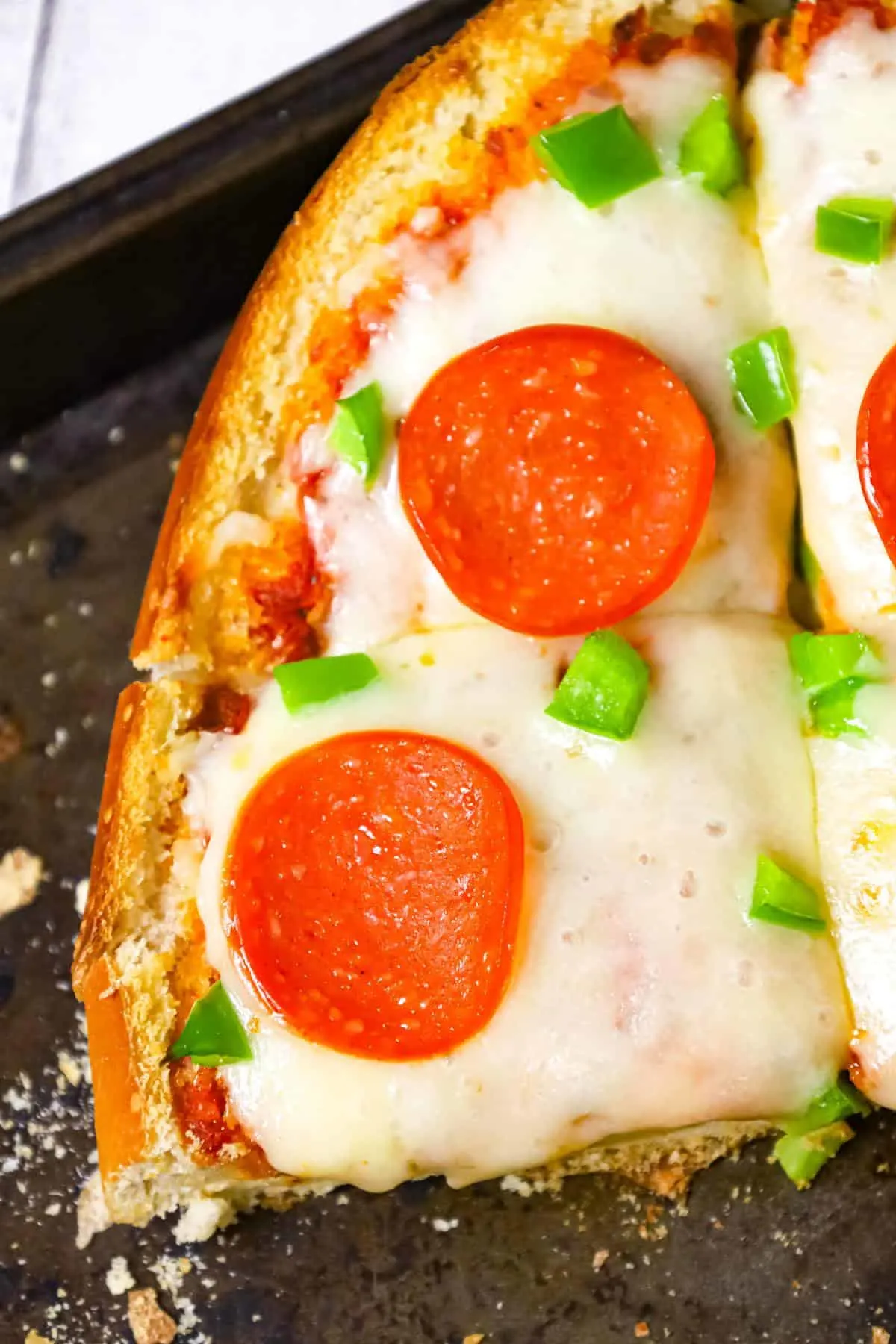 French Bread Pizza is an easy dinner or party snack recipe made with a large loaf of French or Italian bread toasted with garlic butter and topped with pizza sauce, cheese, pepperoni and green peppers.