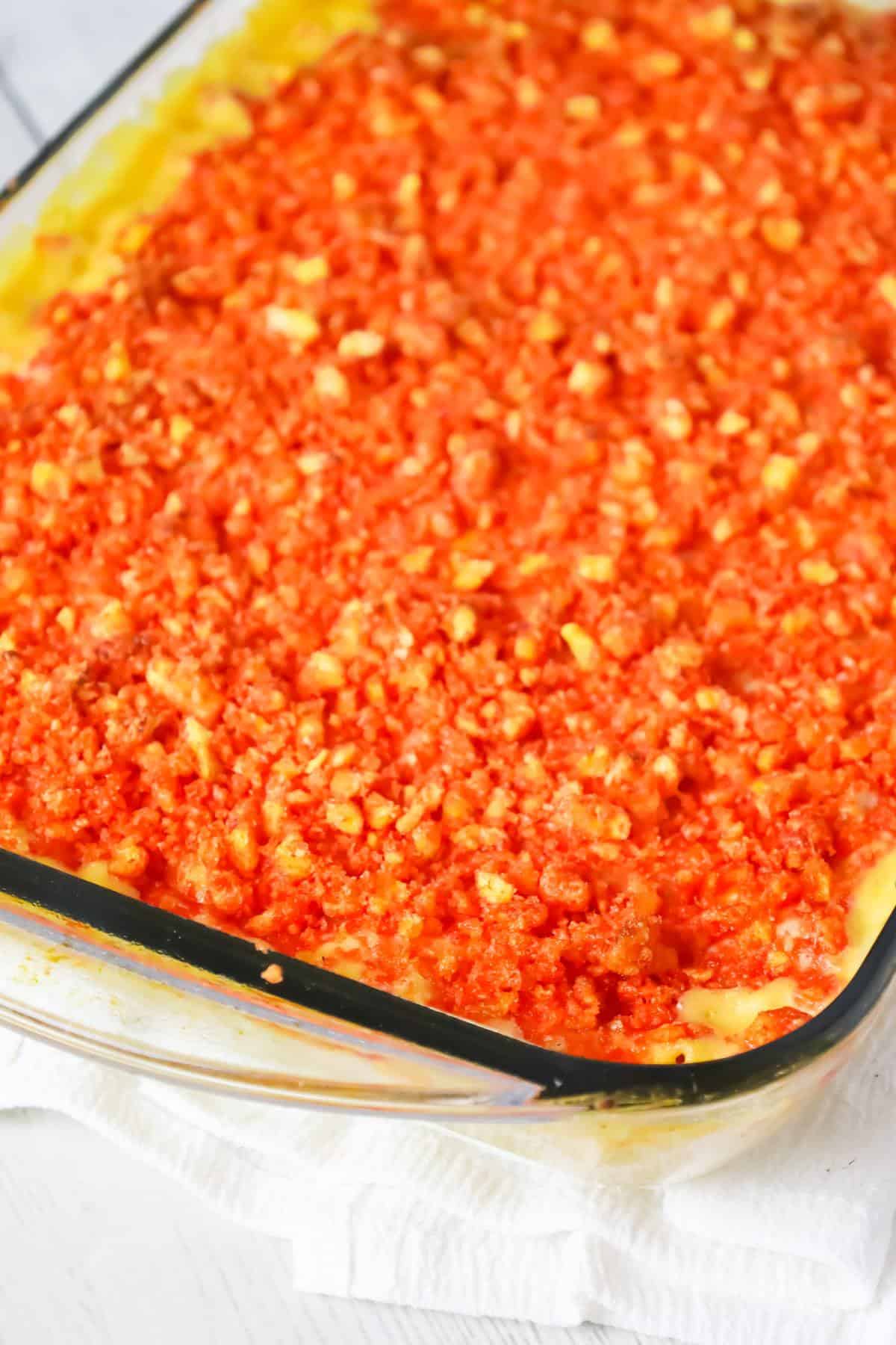 Hot Cheetos Mac and Cheese is a delicious baked pasta recipe loaded with shredded cheddar, mozzarella, banana pepper rings and topped with crumbled Flamin' Hot Cheetos.