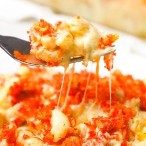 Hot Cheetos Mac and Cheese is a delicious baked pasta recipe loaded with shredded cheddar, mozzarella, banana pepper rings and topped with crumbled Flamin' Hot Cheetos.