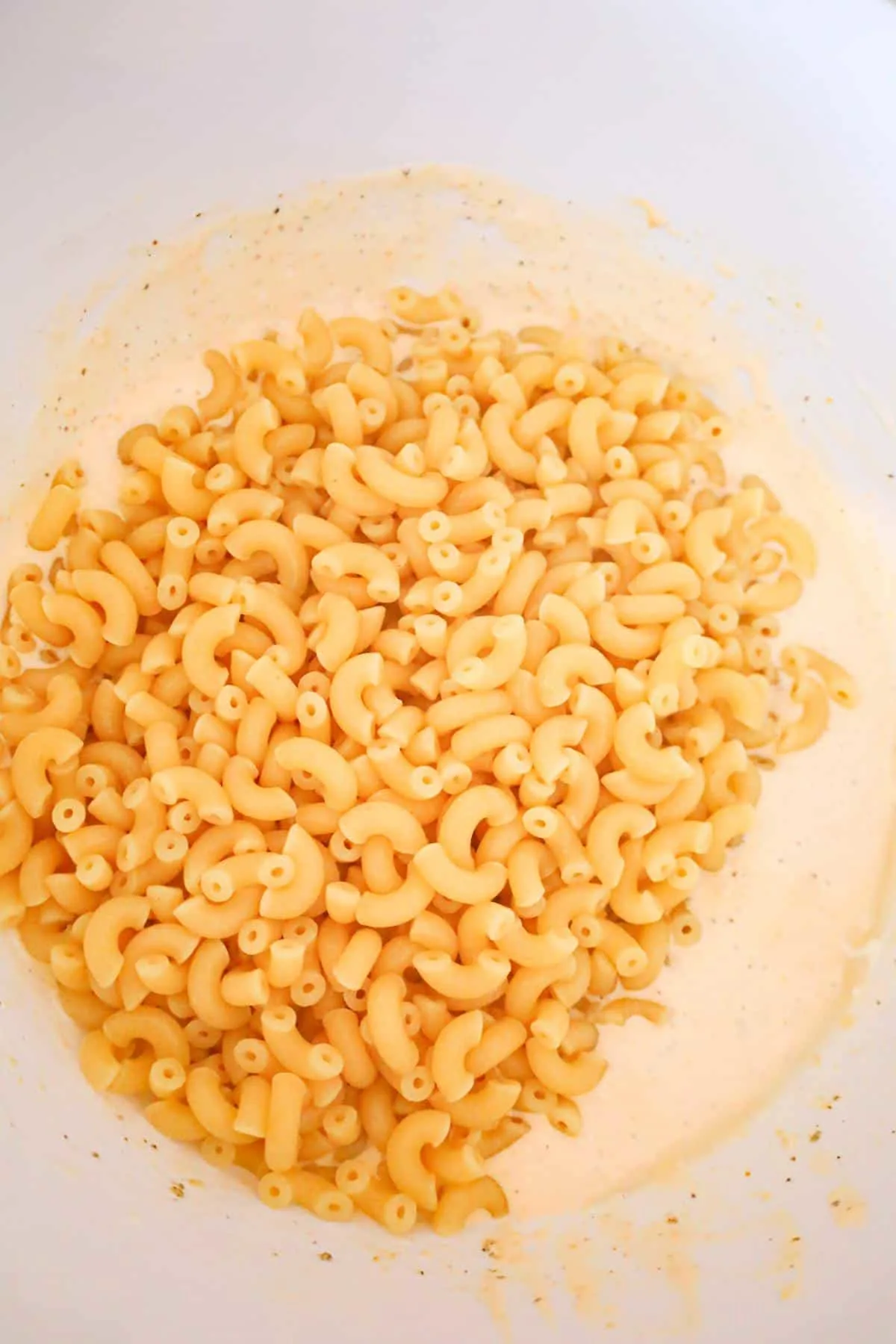cooked macaroni noodles on top of cream and cheddar soup mixture in a mixing bowl