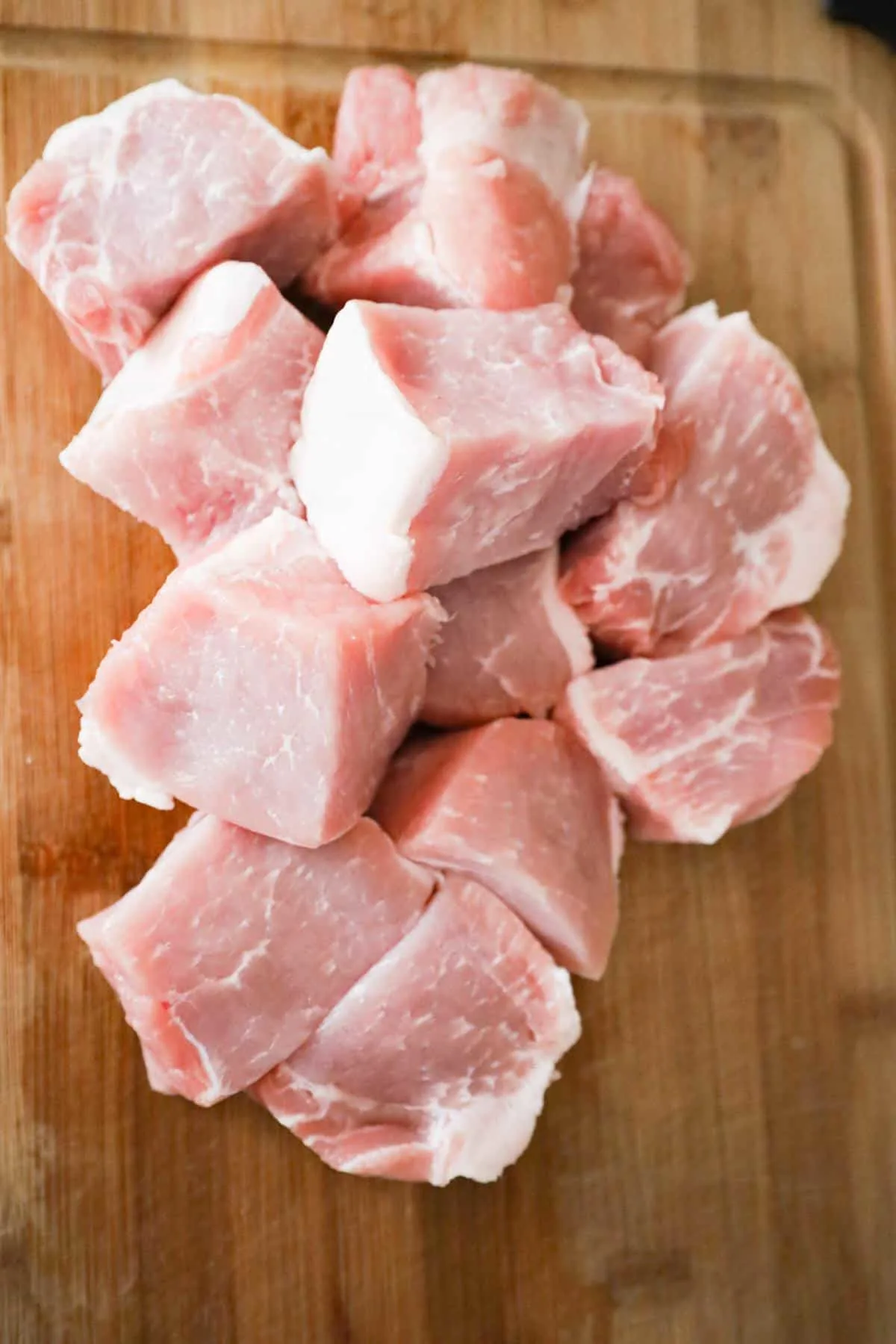 raw pork roast chunks of a cutting board