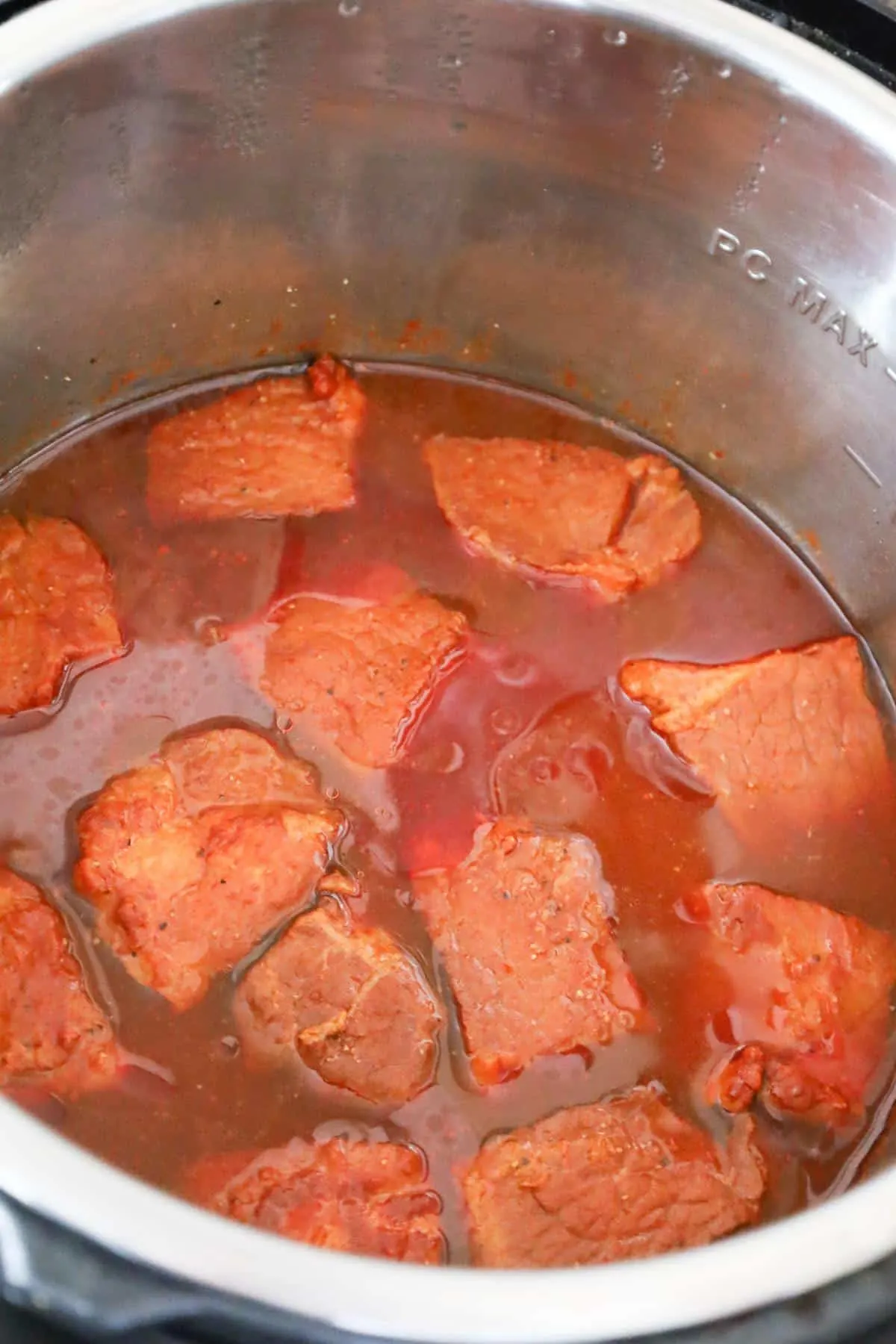 cooked pork chunks in liquid in an Instant Pot