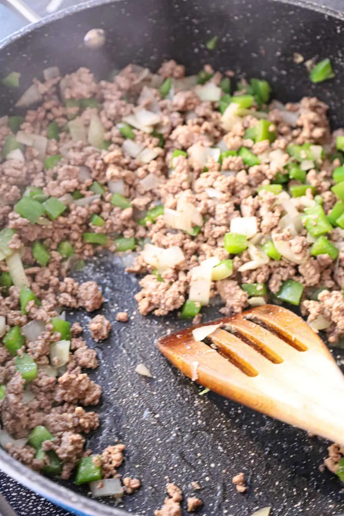 cooked ground beef and diced onions and green peppers in a saute pan
