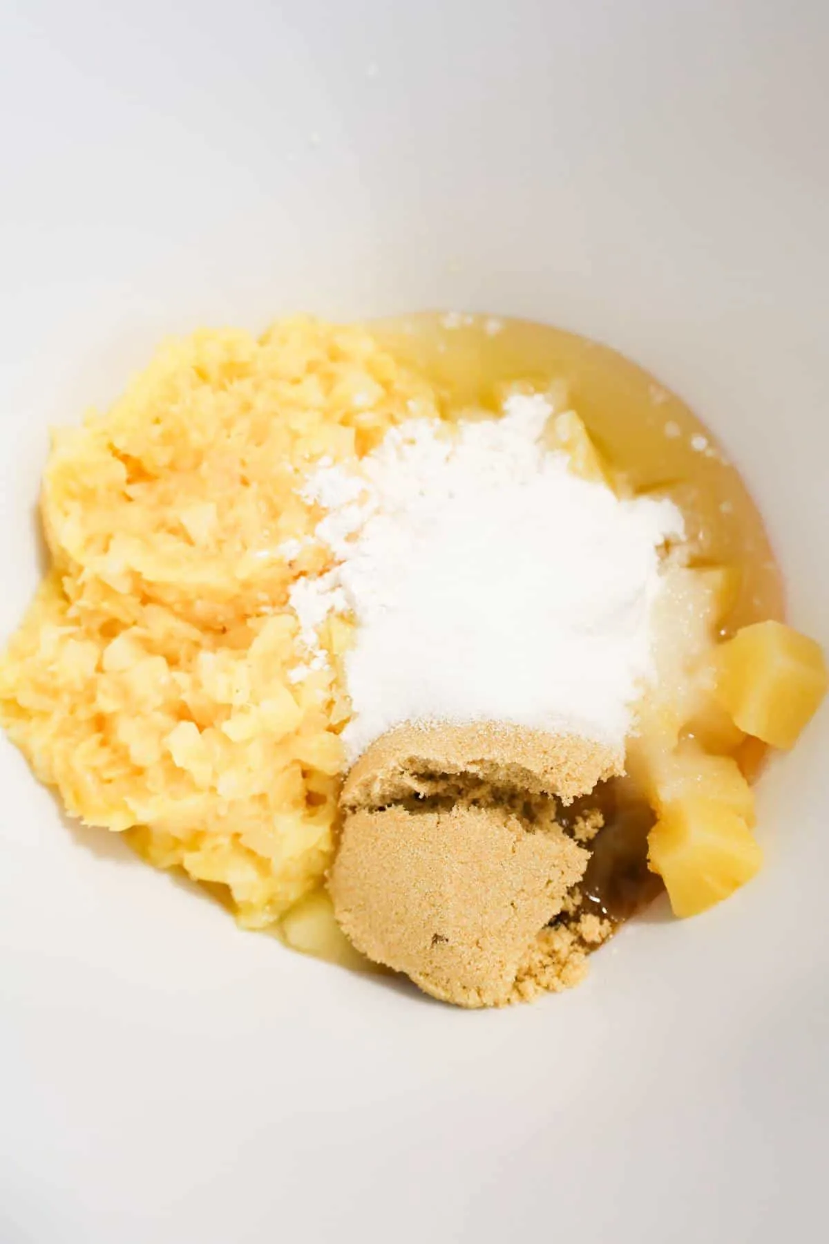 flour, brown sugar, granulated sugar and pineapple in a mixing bowl