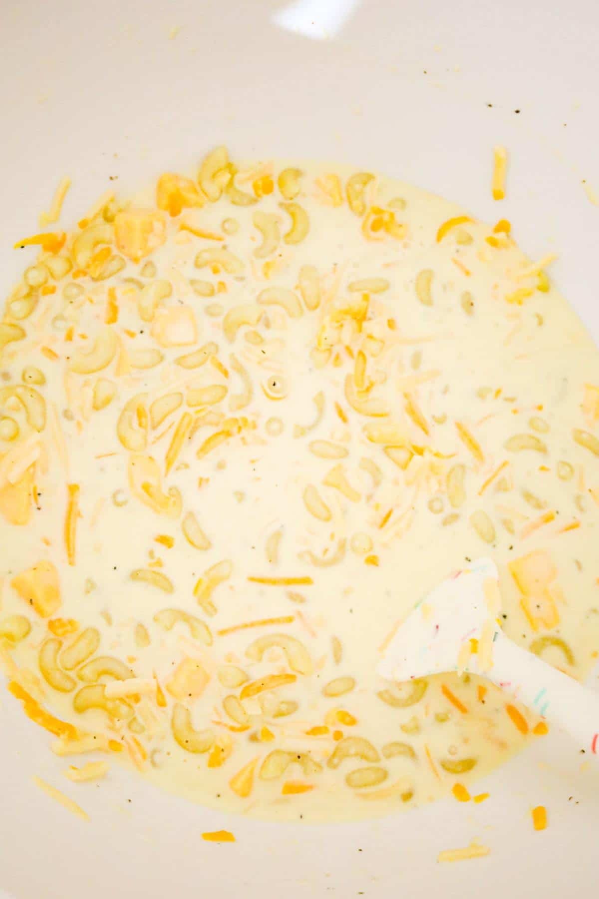 creamy macaroni and cheese mixture in a mixing bowl