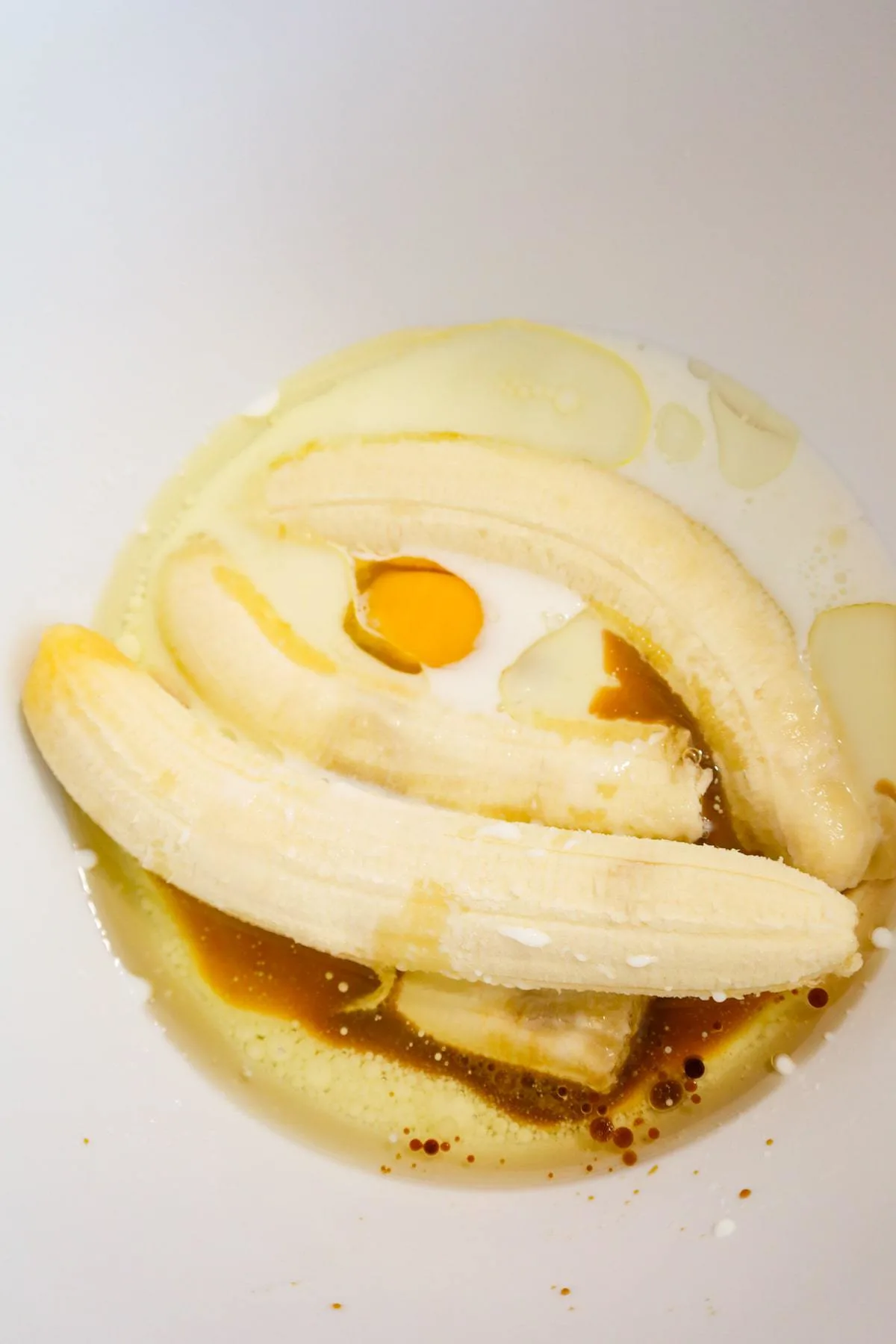 ripe bananas, egg, milk, oil and vanilla extract in a mixing bowl