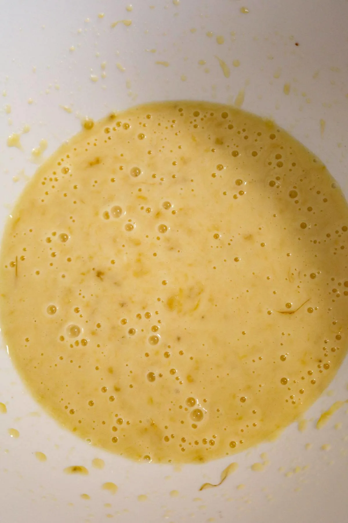 banana, milk, egg and oil mixture in a mixing bowl