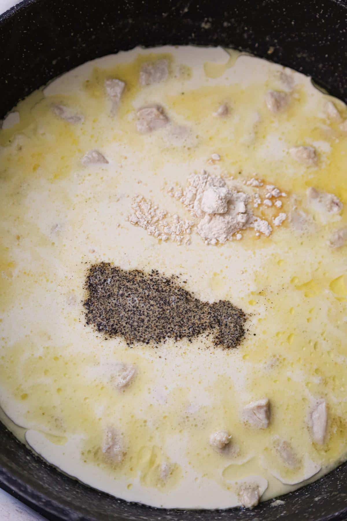 salt, pepper and onion powder on top of heavy cream and butter sauce in a saute pan