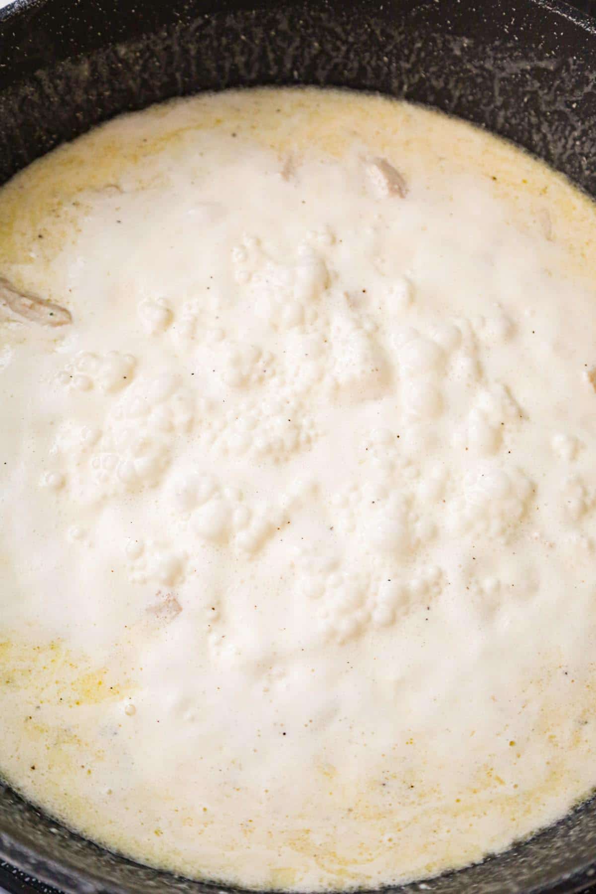 cream sauce bubbling in a saute pan