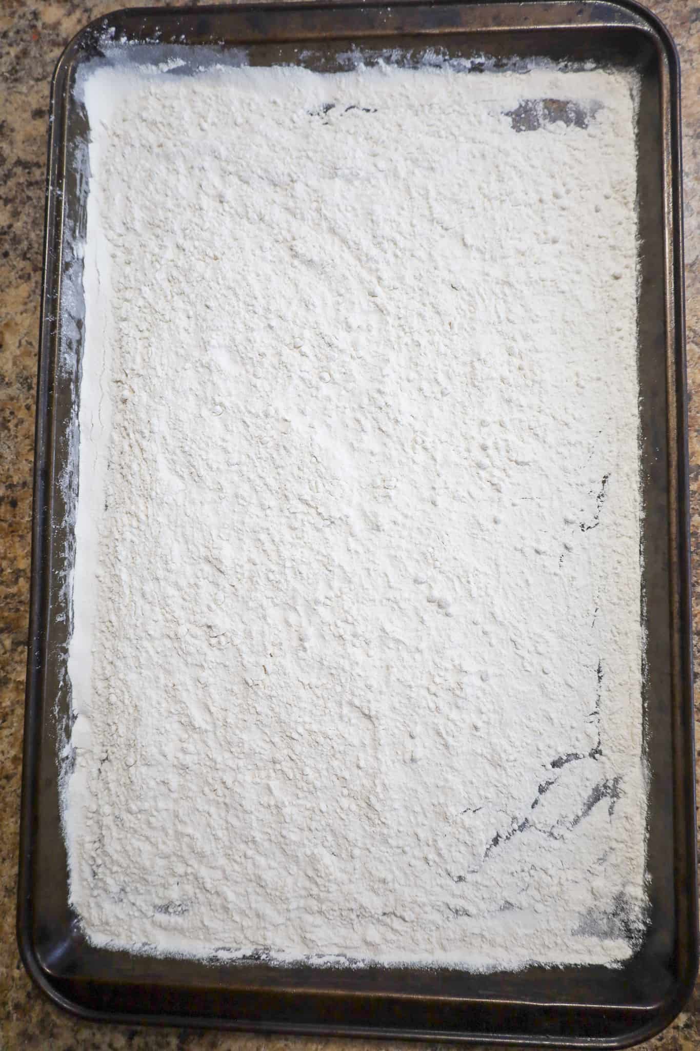 all purpose flour spread out on a baking sheet