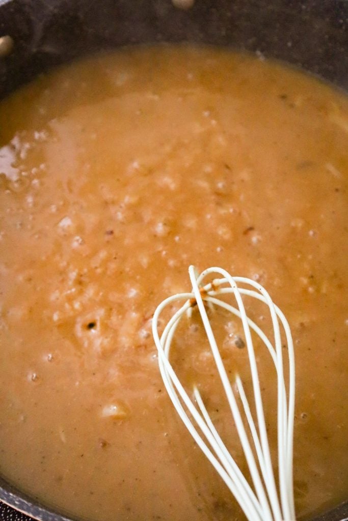 whisking gravy in a pan