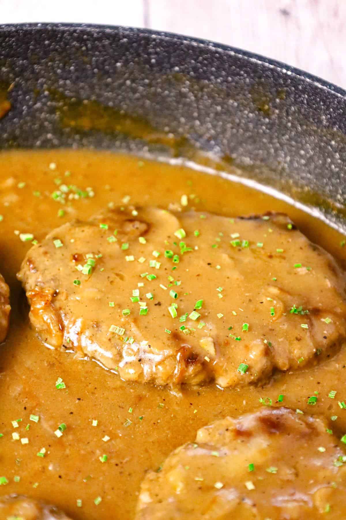 Hamburger Steak is an easy stove top dinner recipe of ground beef patties and onions cooked in brown gravy.