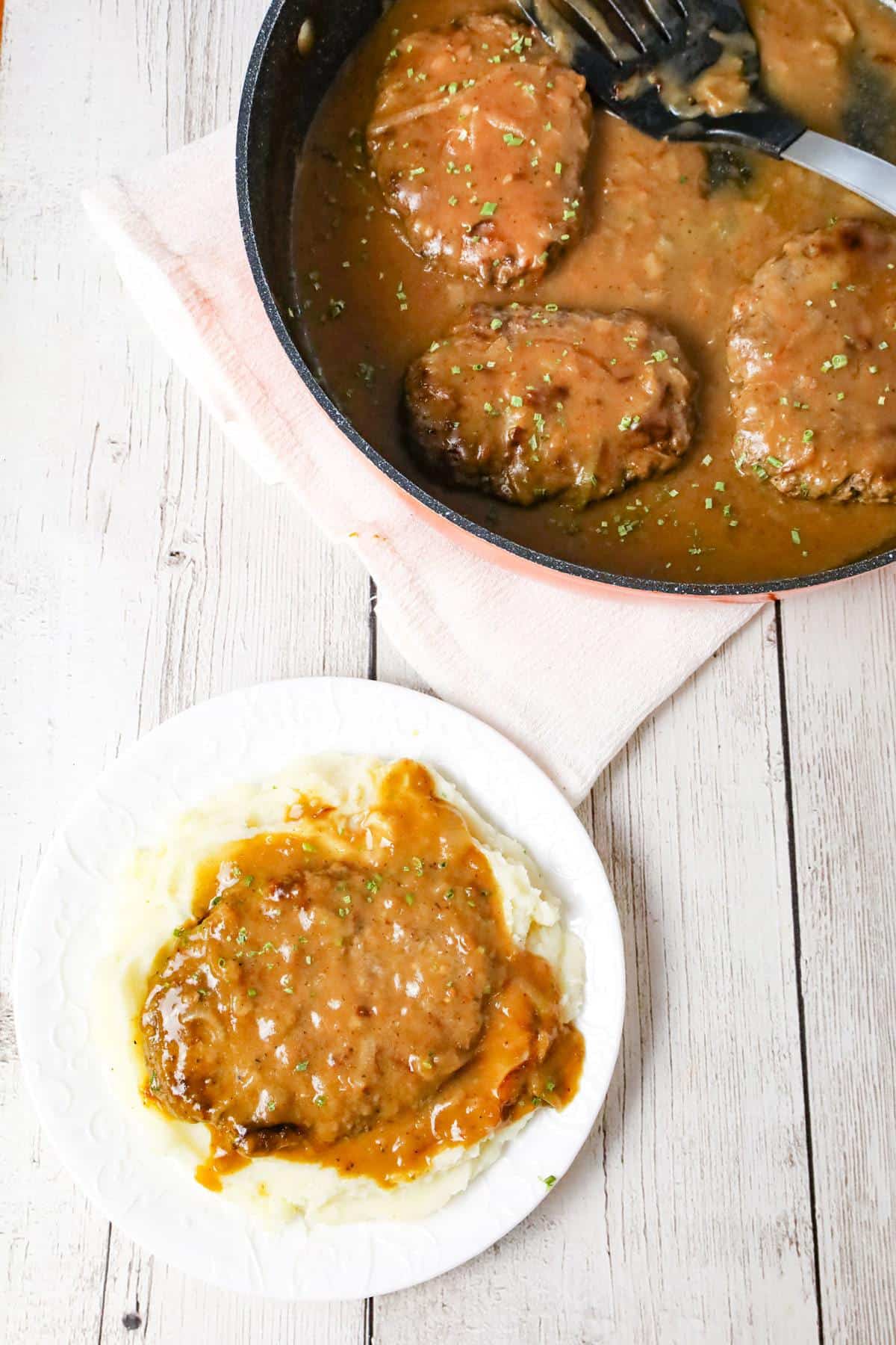 Hamburger Steak is an easy stove top dinner recipe of ground beef patties and onions cooked in brown gravy.