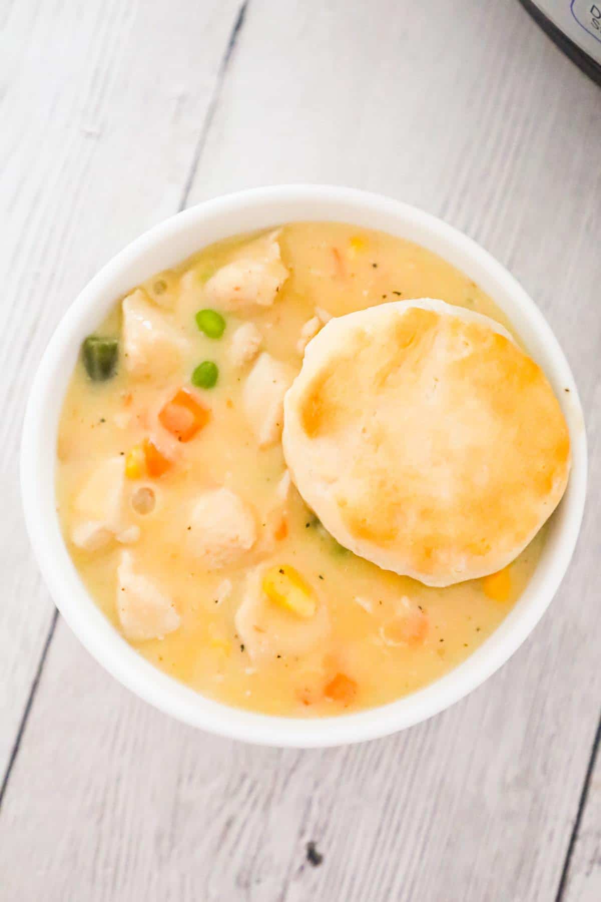Instant Pot Chicken Pot Pie is a tasty comfort food recipe made with boneless skinless chicken breast chunks and frozen mixed vegetables all in a creamy sauce and served with biscuits instead of in a pie crust.