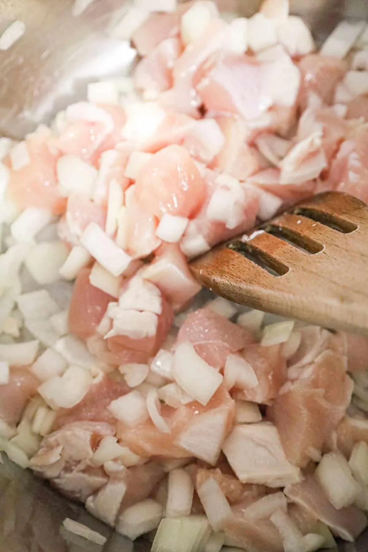 chicken breast chunks and diced onions being cooked in an Instant Pot