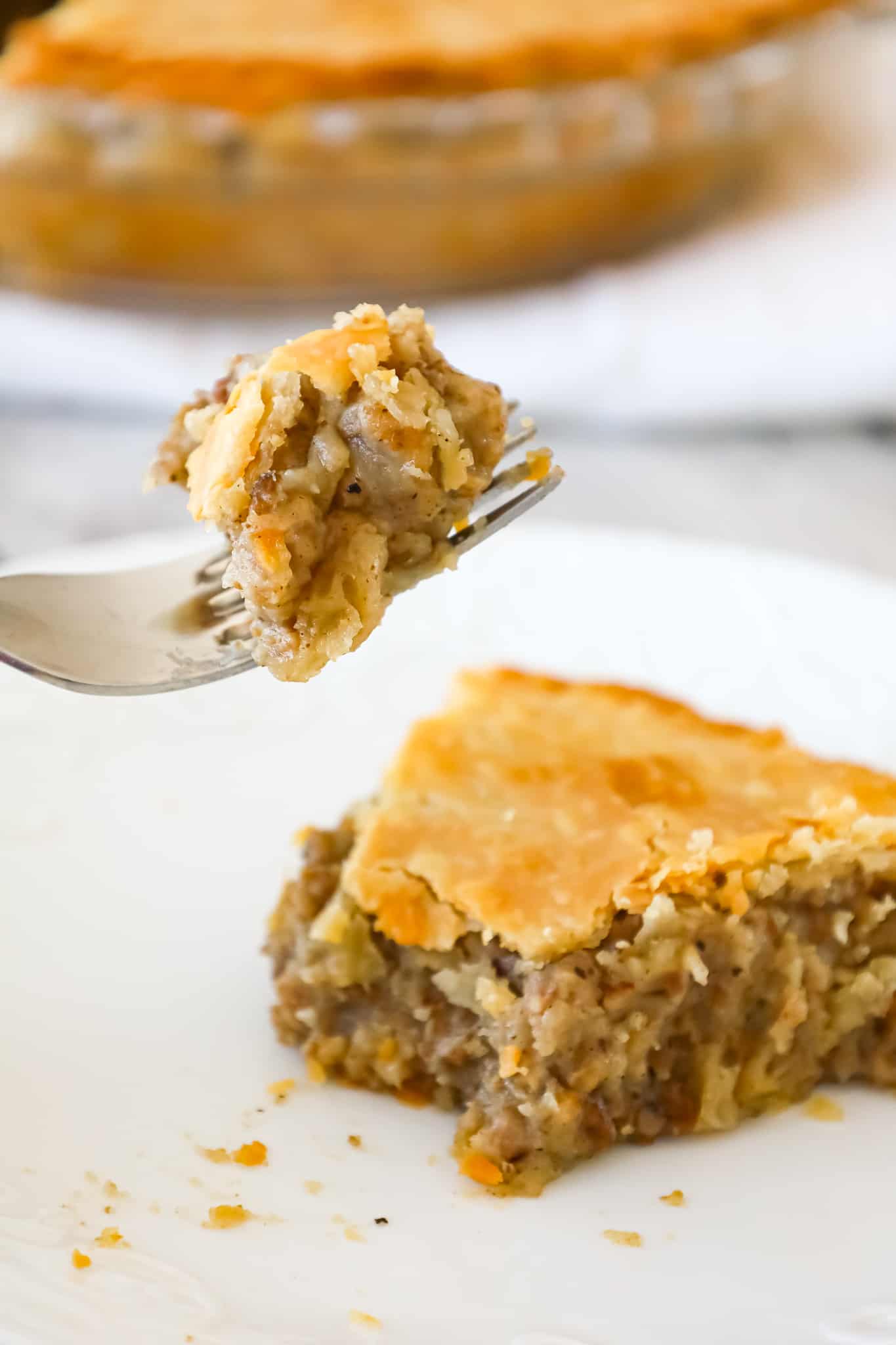 Meat Pie is a hearty dish made with ground beef, ground pork, mashed potatoes and spices all baked inside a flaky pie crust.