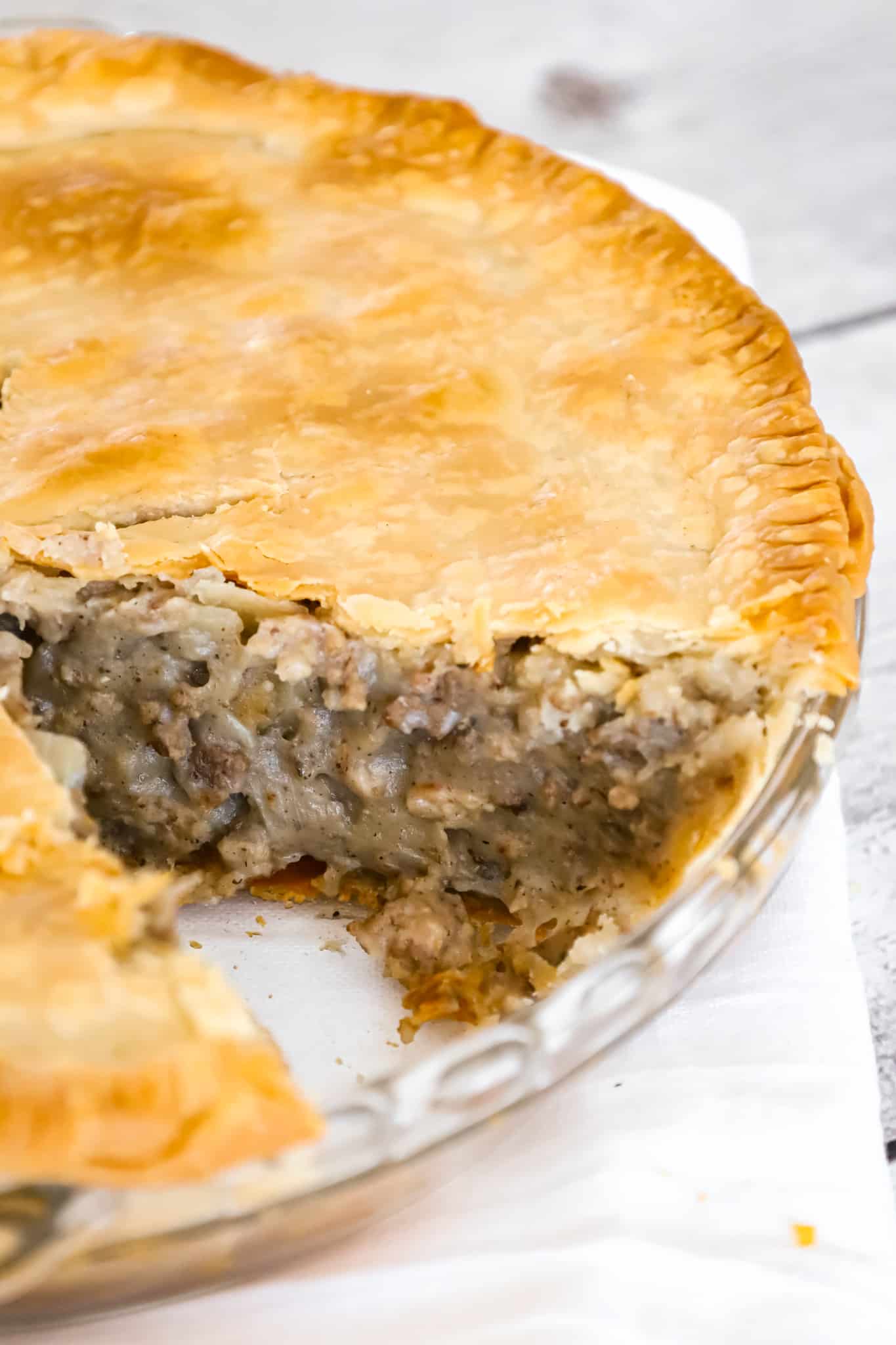 Meat Pie is a hearty dish made with ground beef, ground pork, mashed potatoes and spices all baked inside a flaky pie crust.