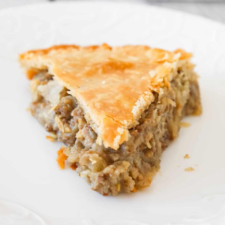 Meat Pie is a hearty dish made with ground beef, ground pork, mashed potatoes and spices all baked inside a flaky pie crust.