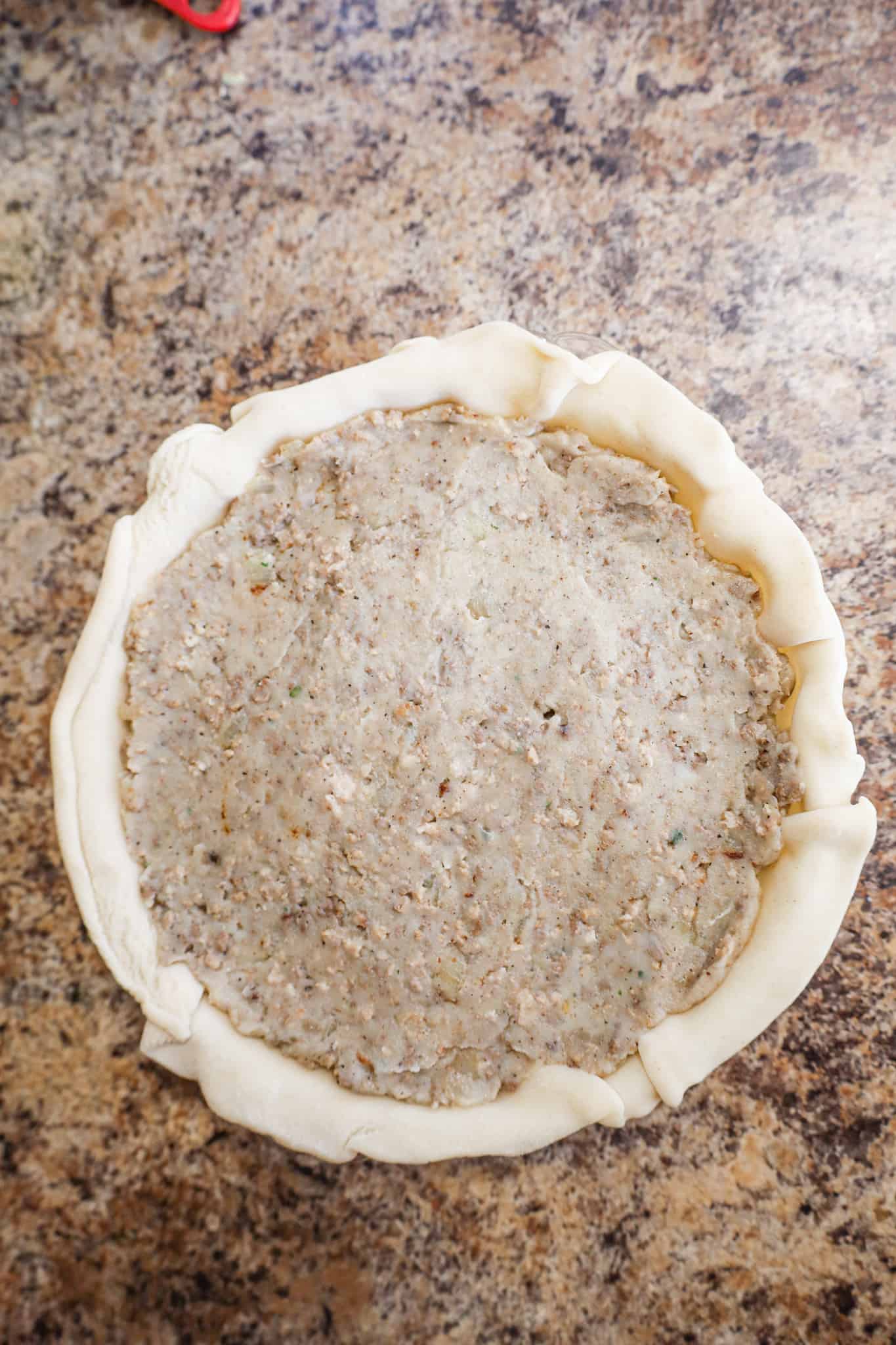 ground meat and potato mixture in an unbaked pie crust