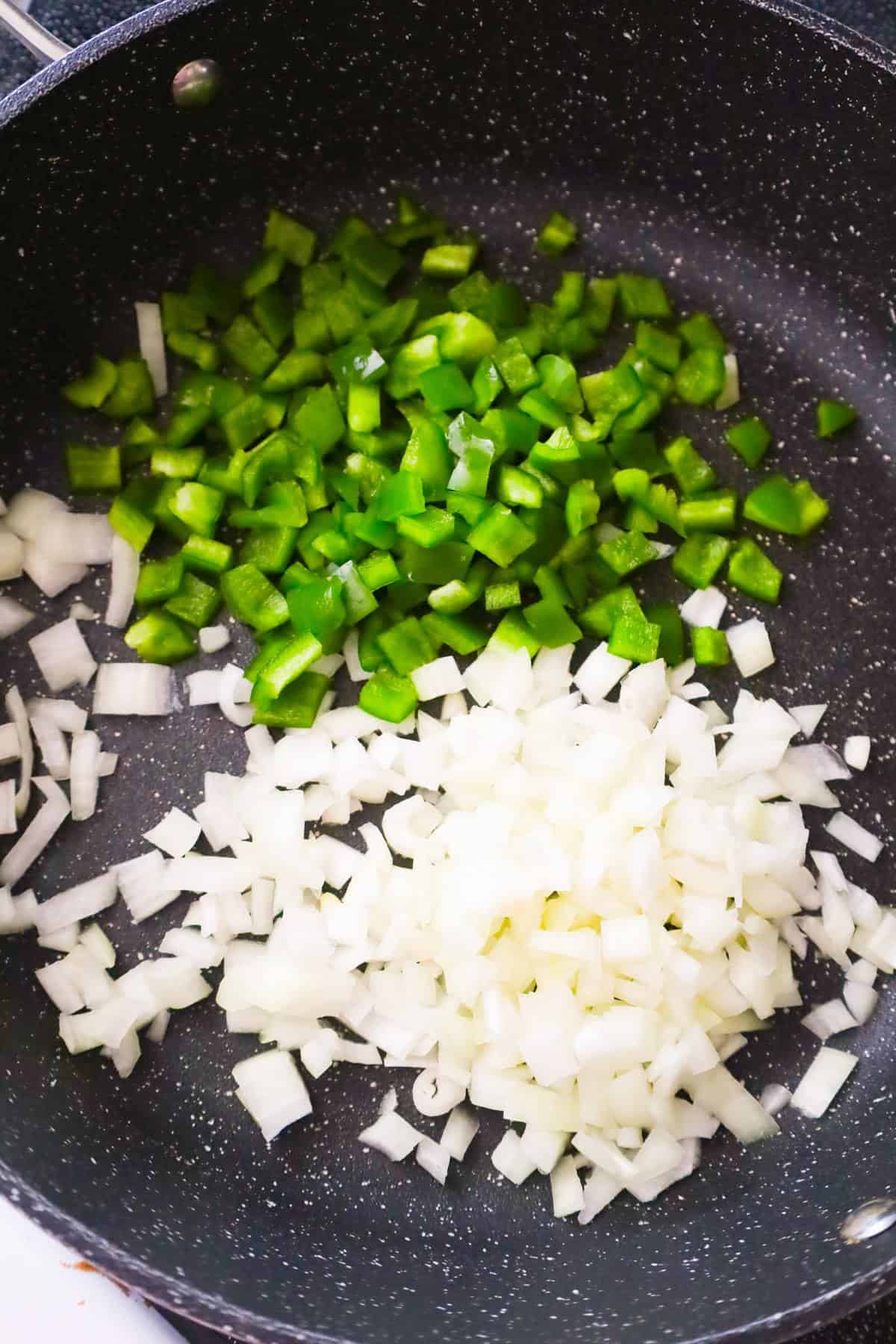 diced green peppers and diced onions in a saute pan