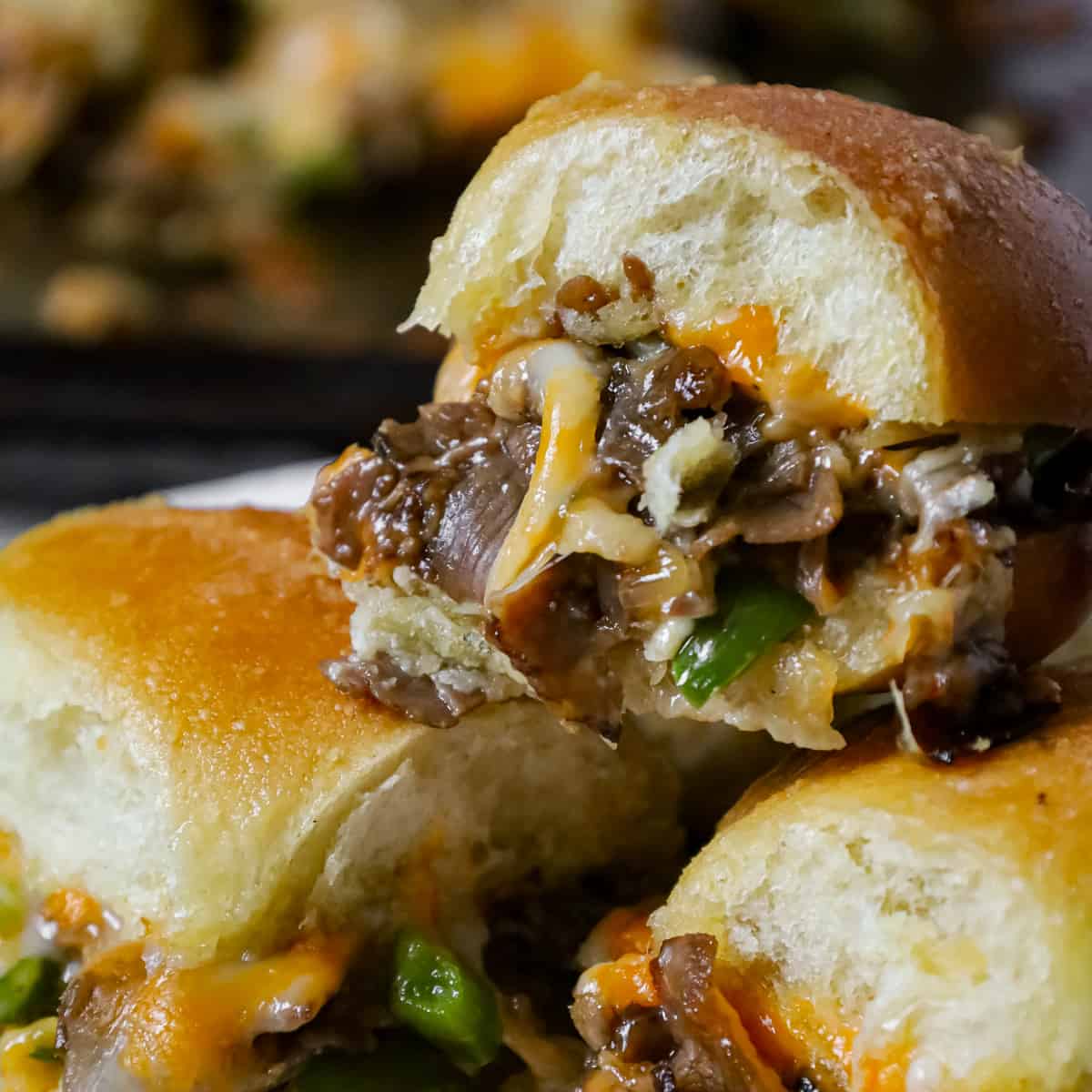 Philly Cheese Steak Sliders are delicious mini sandwiches loaded with chopped roast beef, green peppers, onions and shredded cheese.