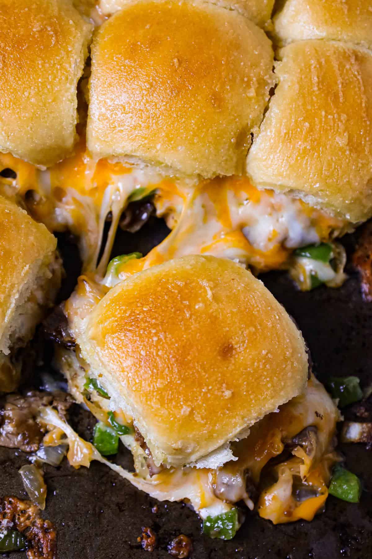 Philly Cheese Steak Sliders are delicious mini sandwiches loaded with chopped roast beef, green peppers, onions and shredded cheese.