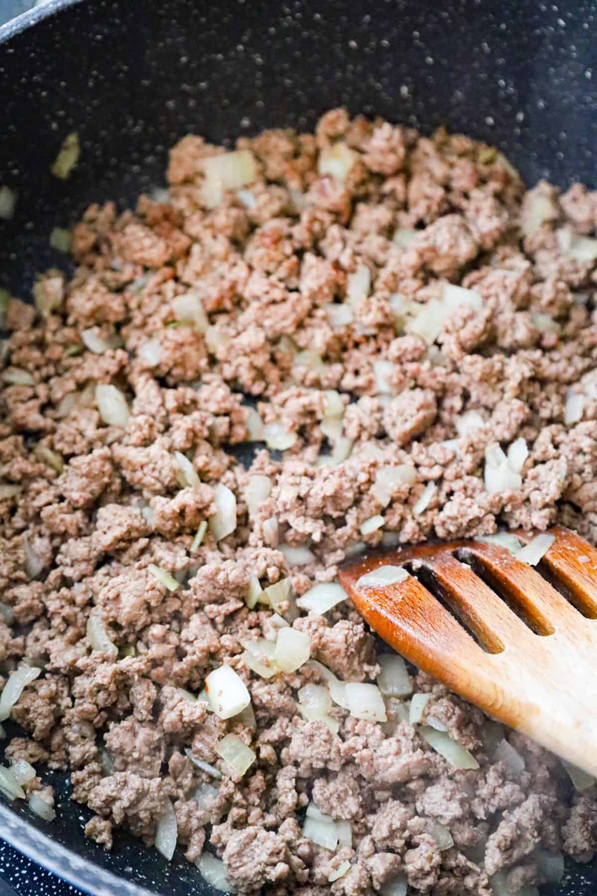 cooked ground beef and onions in a saute pan