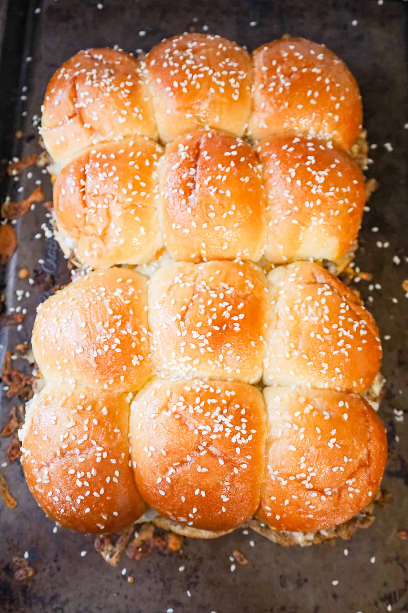 melted butter and sesame seeds on top of cheeseburger sliders