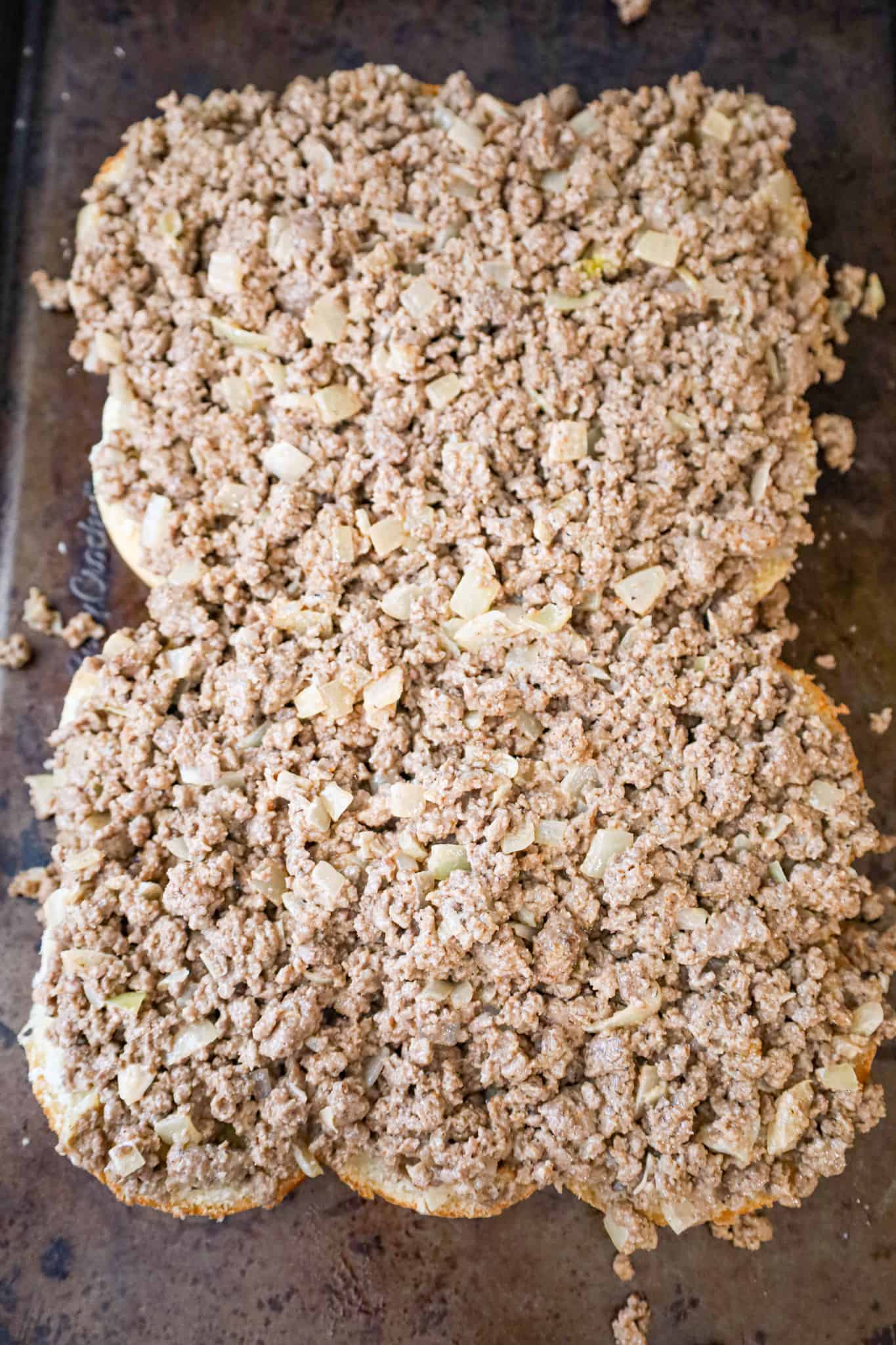 ground beef mixture on top of dinner rolls on baking sheet