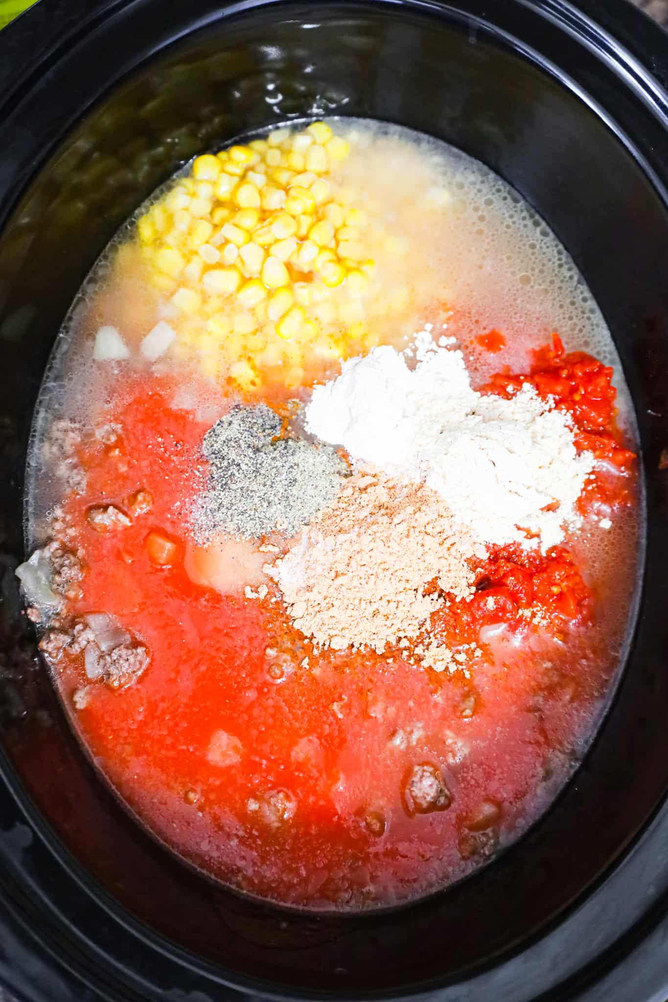 spices on top of tomato sauce, Rotel and corn in a crock pot