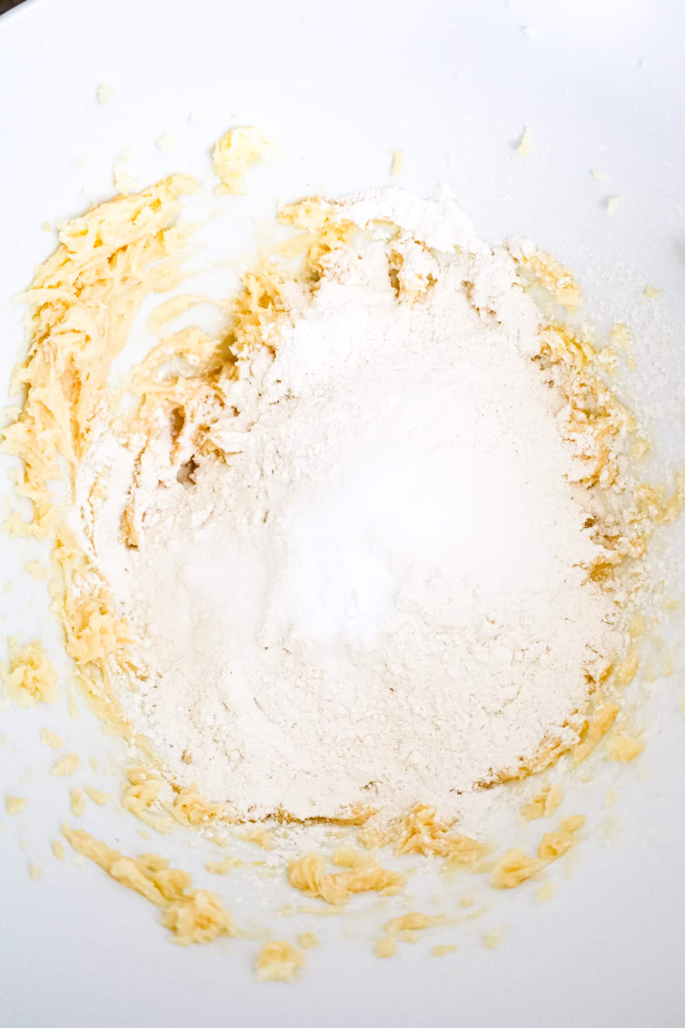 salt, baking soda and all purpose flour on top of butter and sugar mixture in a mixing bowl