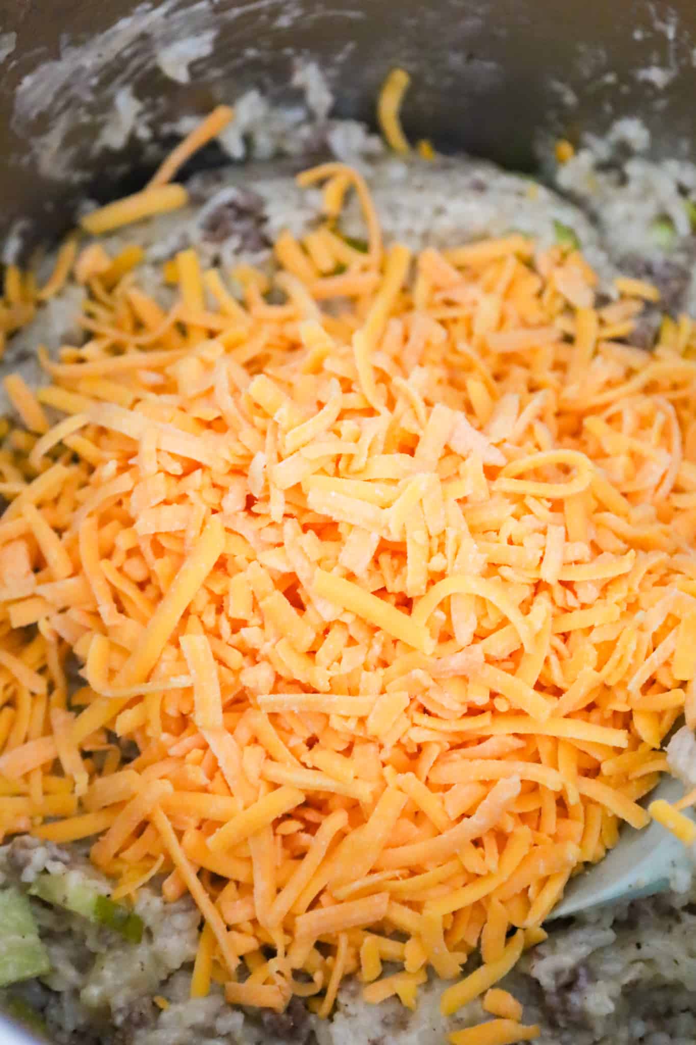 shredded cheese on top of ground beef and rice in an Instant Pot