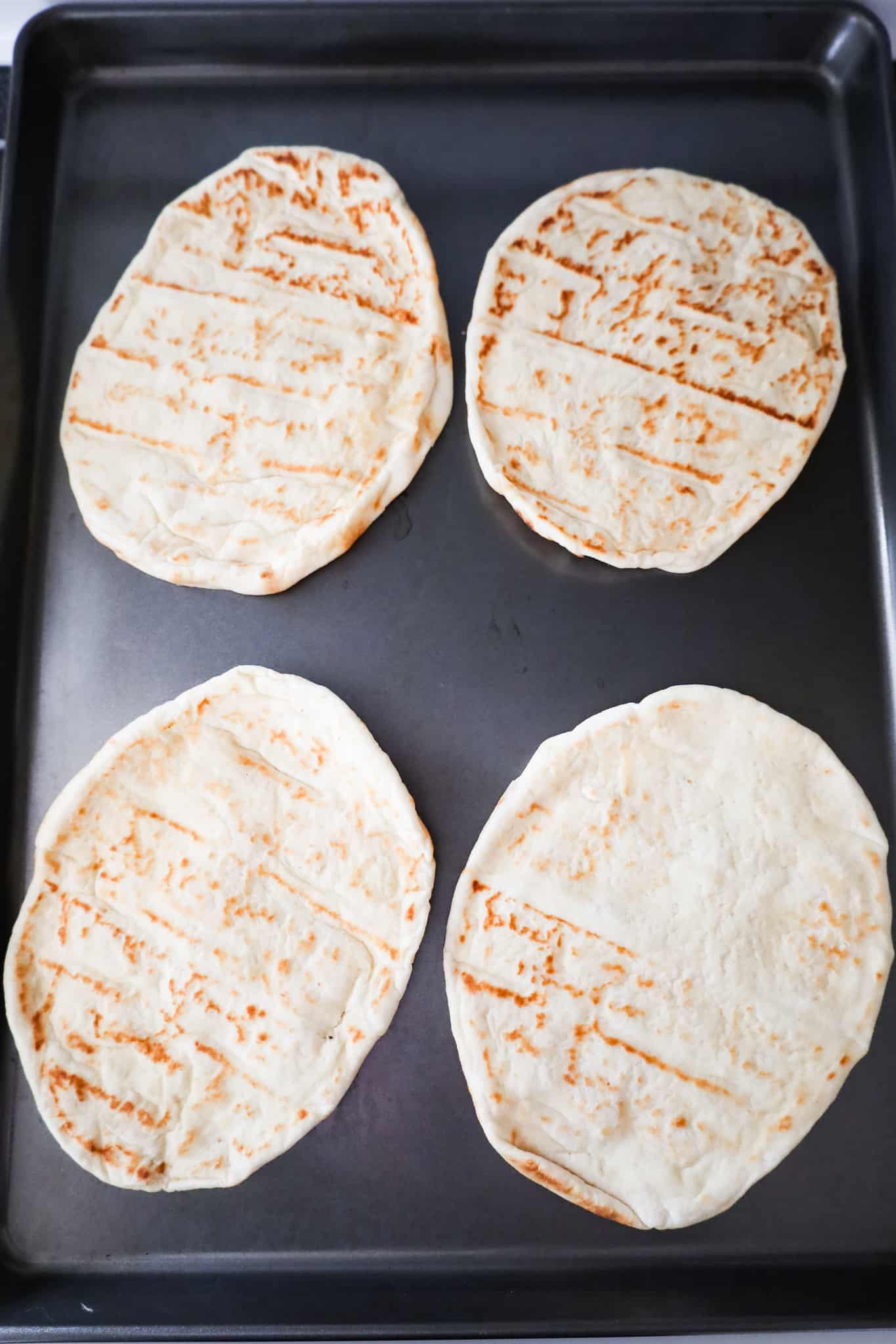naan breads on a baking sheet