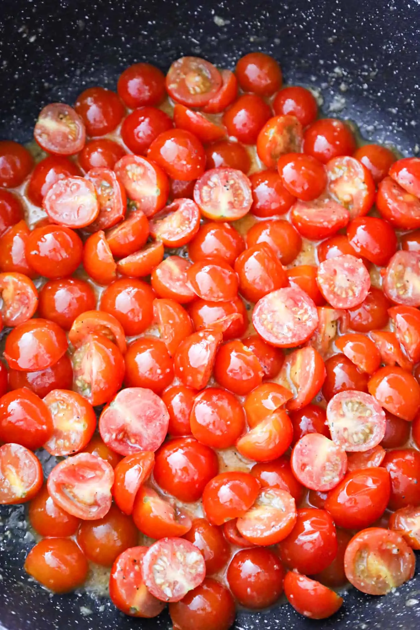 halved cherry tomatoes in a saute pan