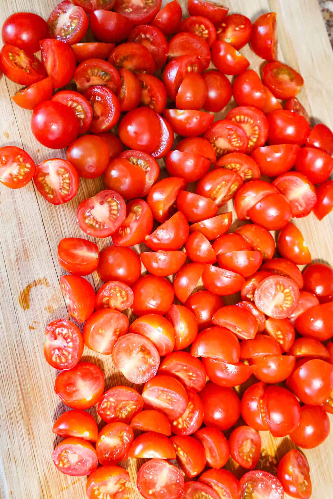 cherry tomato halves on a cutting board