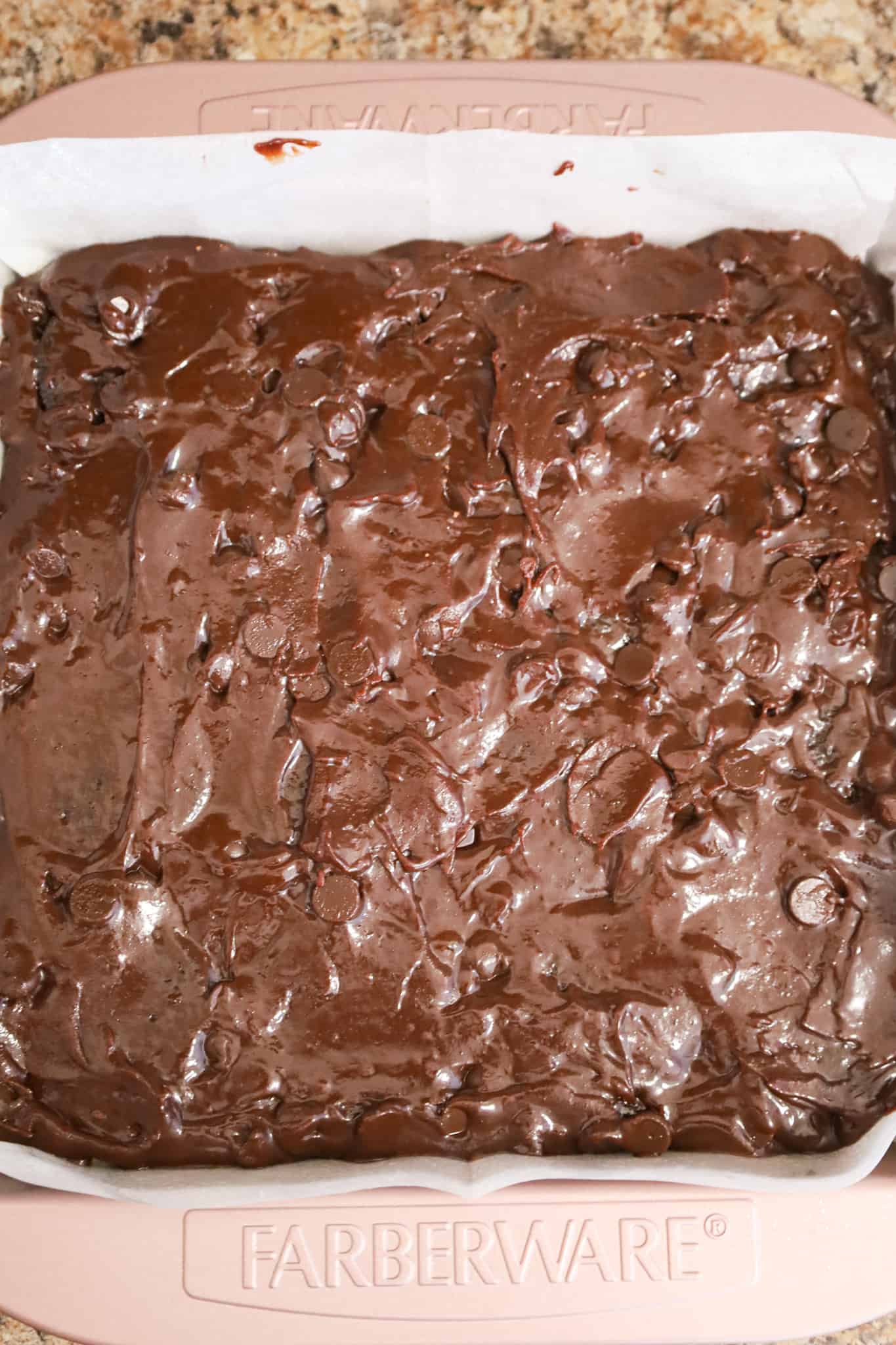 brownie batter in a parchment lined baking dish