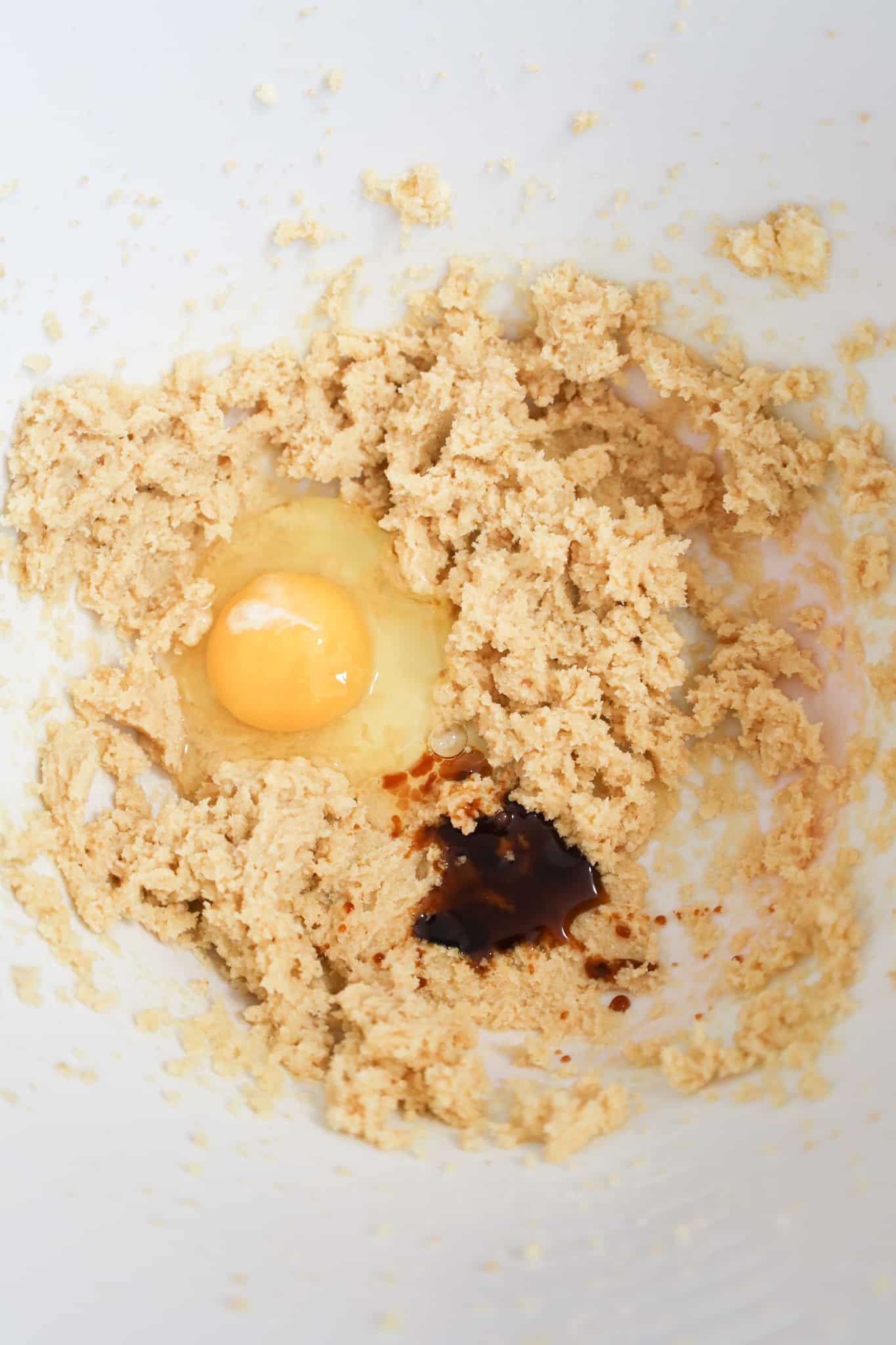egg and vanilla extract on top of creamed butter and sugar mixture in a mixing bowl